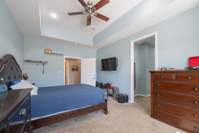 bedroom featuring light carpet, baseboards, a ceiling fan, a tray ceiling, and recessed lighting