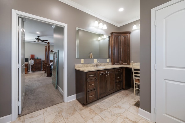 bathroom featuring ceiling fan, ornamental molding, vanity, and baseboards