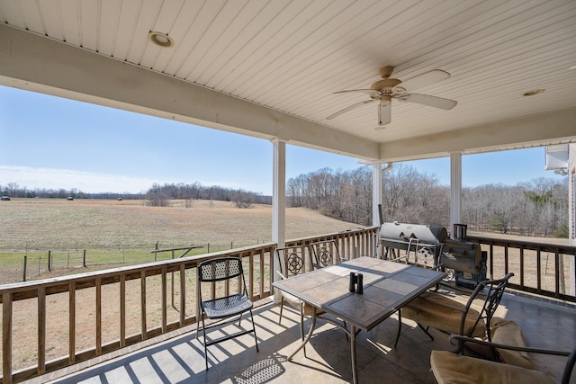 wooden deck featuring ceiling fan and a rural view