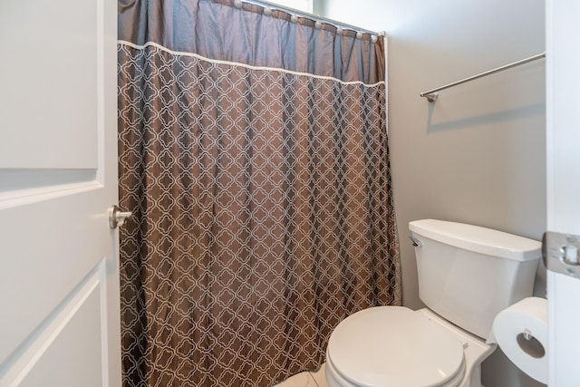 full bath with toilet and a shower with curtain