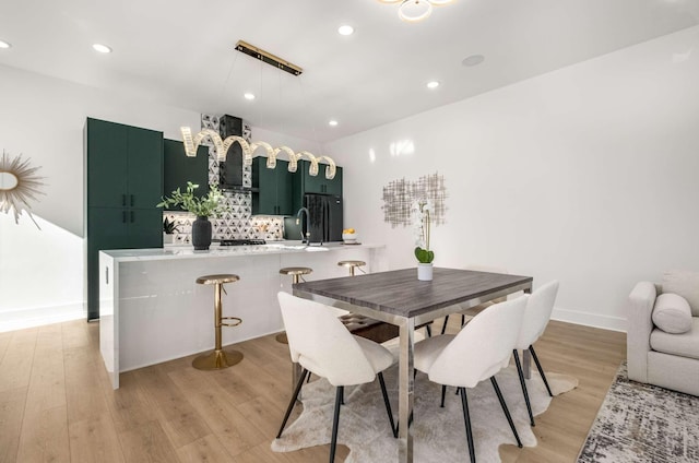 dining room featuring recessed lighting, baseboards, and light wood finished floors