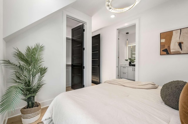 bedroom featuring connected bathroom and baseboards