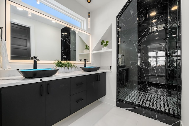 full bath with double vanity, a sink, and a marble finish shower