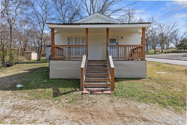 view of outbuilding featuring covered porch and stairway