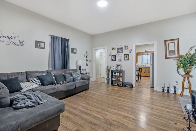 living room with baseboards and light wood finished floors