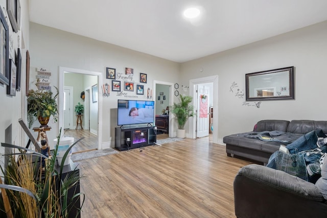 living room featuring light wood-type flooring and baseboards