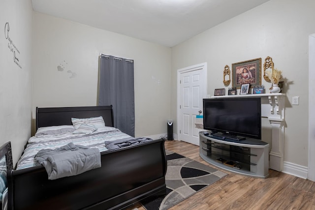 bedroom featuring baseboards and wood finished floors