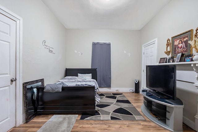 bedroom featuring baseboards and wood finished floors