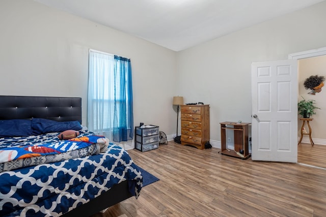 bedroom with baseboards and wood finished floors