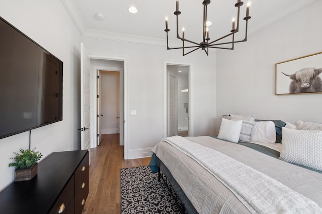 bedroom with crown molding, an inviting chandelier, ensuite bathroom, wood finished floors, and baseboards