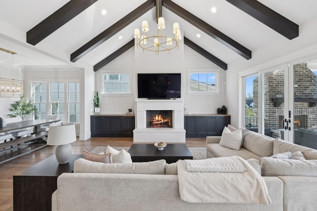 living room with a warm lit fireplace, a healthy amount of sunlight, and a notable chandelier