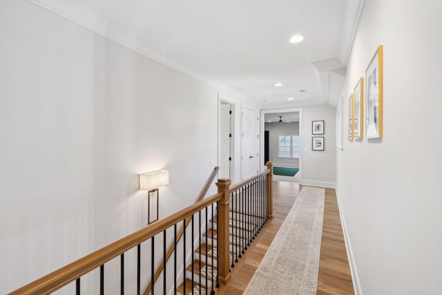 corridor with recessed lighting, an upstairs landing, baseboards, light wood-style floors, and ornamental molding