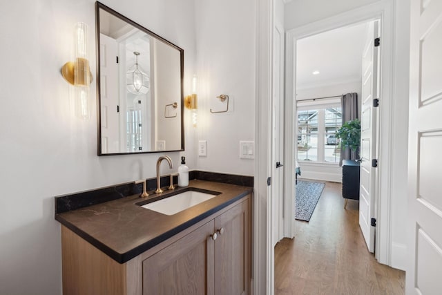 bathroom featuring wood finished floors, vanity, and crown molding