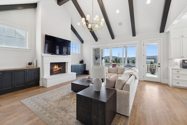 living room featuring high vaulted ceiling, light wood-style flooring, recessed lighting, a lit fireplace, and beamed ceiling