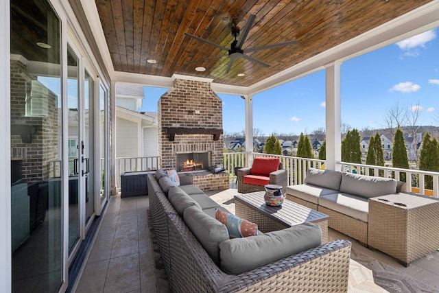 view of patio with an outdoor living space with a fireplace and ceiling fan