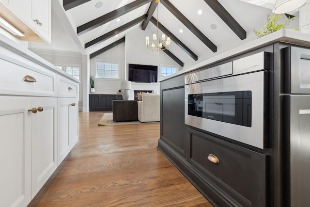 kitchen with light wood-style floors, a wealth of natural light, white cabinets, and an inviting chandelier