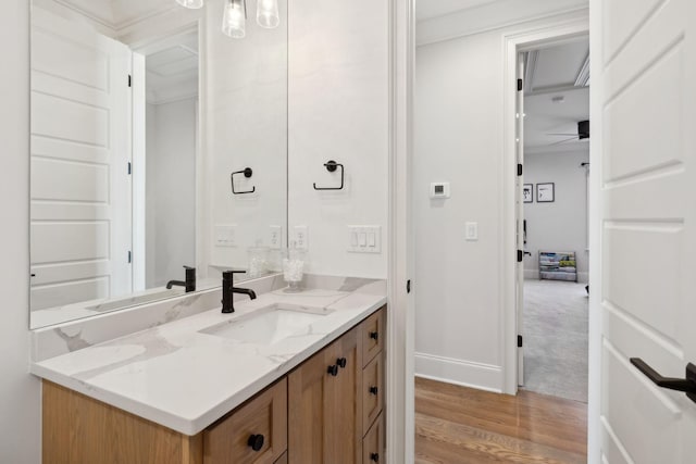 bathroom featuring a ceiling fan, baseboards, wood finished floors, and vanity