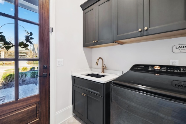 laundry area with a wealth of natural light, washer / clothes dryer, cabinet space, and a sink