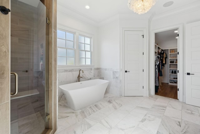 bathroom featuring ornamental molding, a soaking tub, a shower stall, and a spacious closet