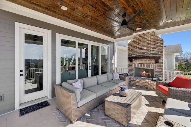 view of patio / terrace with an outdoor living space with a fireplace and a ceiling fan