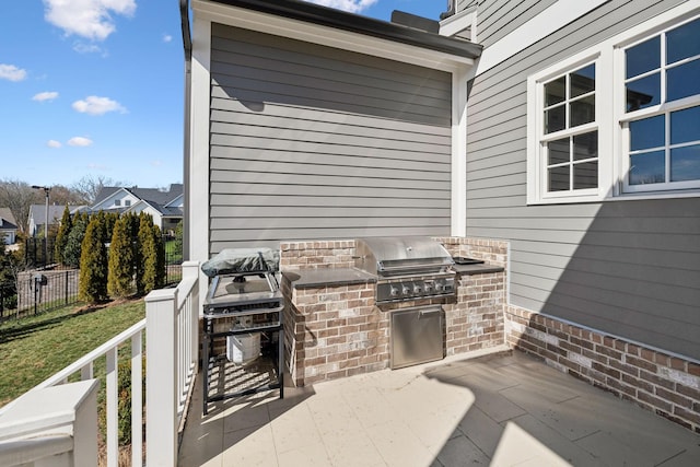 view of patio / terrace featuring area for grilling, an outdoor kitchen, and fence