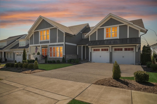 craftsman house with metal roof, an attached garage, concrete driveway, board and batten siding, and a standing seam roof