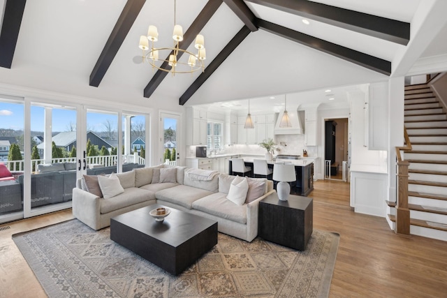 living room with wood finished floors, beamed ceiling, stairs, high vaulted ceiling, and a notable chandelier