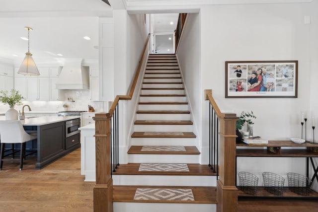 staircase with recessed lighting and wood finished floors