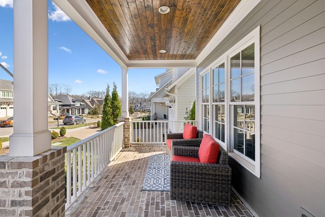 balcony featuring covered porch, a residential view, and visible vents