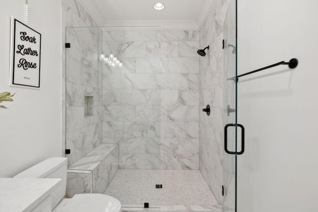 bathroom with vanity, a shower stall, toilet, and crown molding