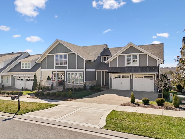 view of front of home with aphalt driveway, an attached garage, a standing seam roof, board and batten siding, and a front yard