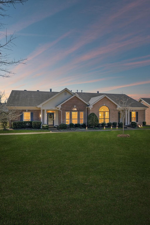 view of front facade featuring a yard and brick siding