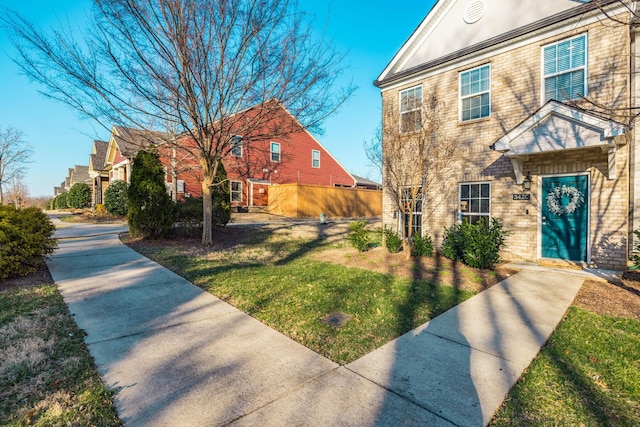 view of front of home featuring brick siding and a front yard