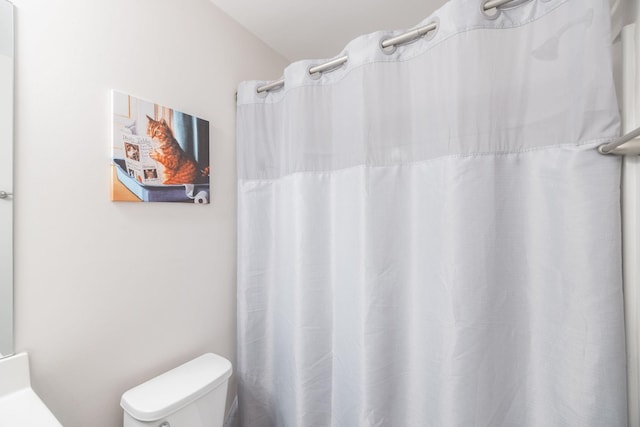 full bathroom with a shower with shower curtain and toilet