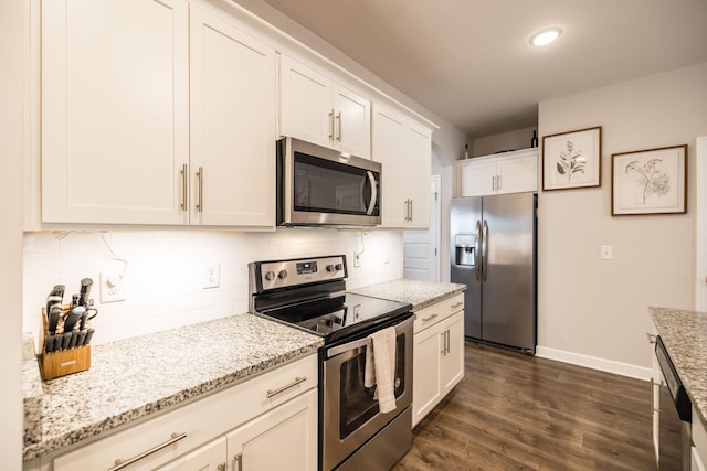 kitchen featuring dark wood-style flooring, baseboards, white cabinets, appliances with stainless steel finishes, and tasteful backsplash