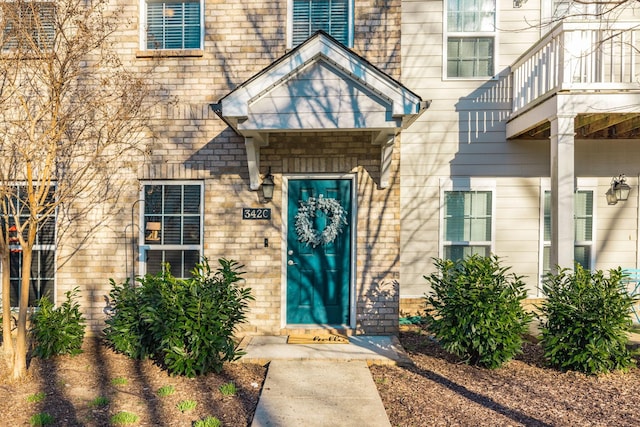 view of exterior entry featuring brick siding