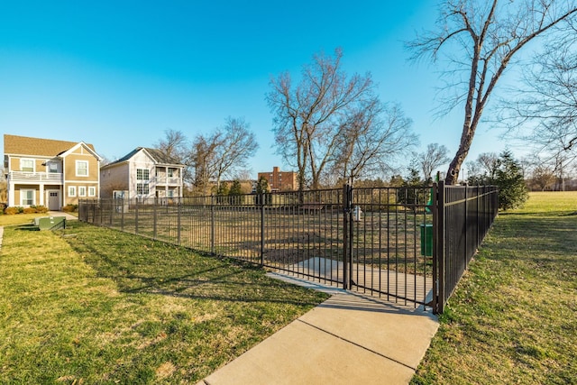 view of gate with a yard and fence