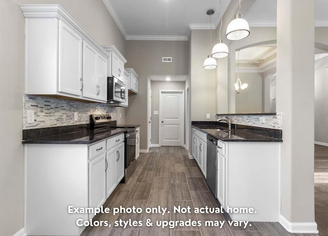 kitchen with stainless steel appliances, a sink, visible vents, white cabinets, and ornamental molding