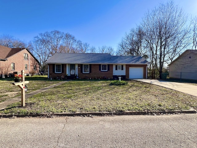 single story home with metal roof, an attached garage, brick siding, concrete driveway, and a front yard