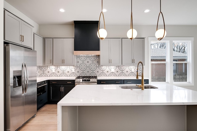 kitchen featuring stainless steel appliances, premium range hood, a sink, backsplash, and light stone countertops