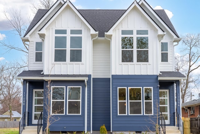 view of front of property with roof with shingles, board and batten siding, and fence