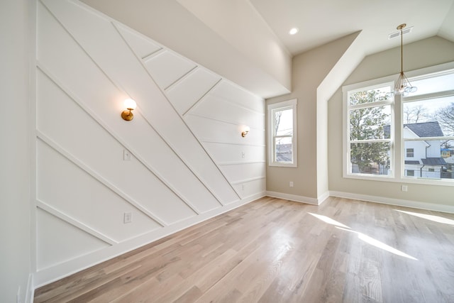 interior space featuring visible vents, baseboards, lofted ceiling, light wood-style flooring, and recessed lighting