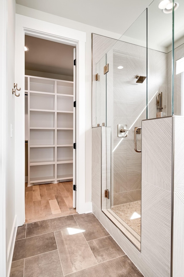 full bath featuring a spacious closet and a shower stall