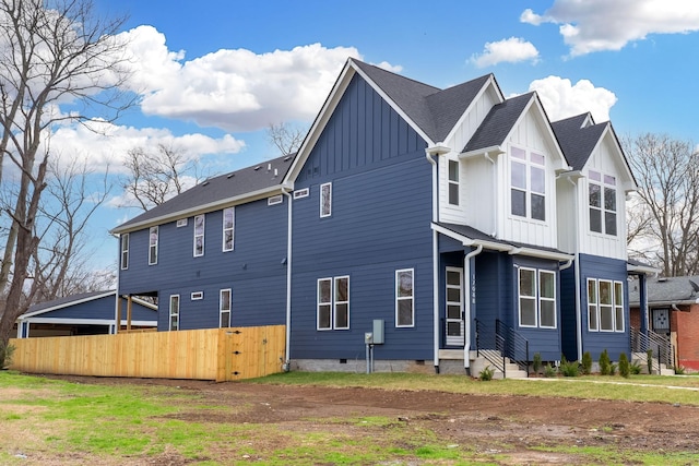 back of house featuring board and batten siding, crawl space, roof with shingles, and fence