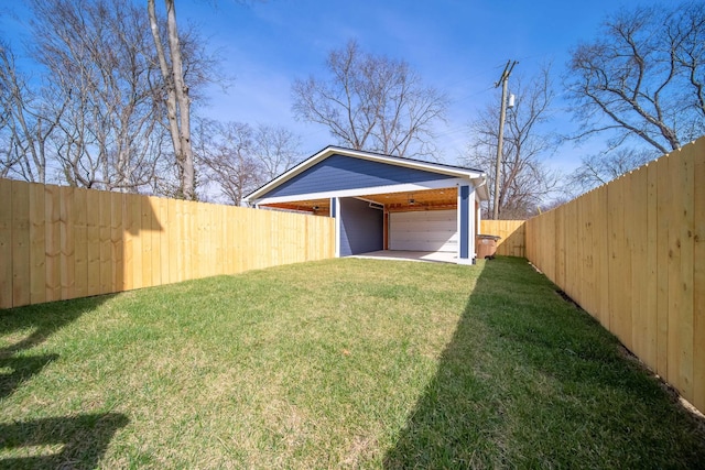 view of yard with a garage and a fenced backyard