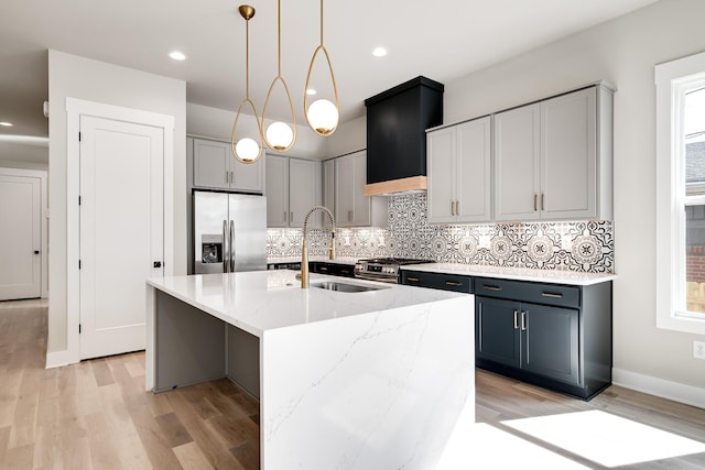 kitchen featuring light wood-type flooring, light stone countertops, appliances with stainless steel finishes, and backsplash