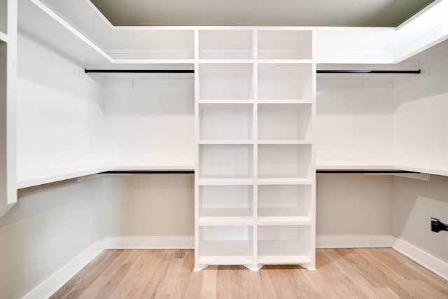 walk in closet featuring wood finished floors and built in study area