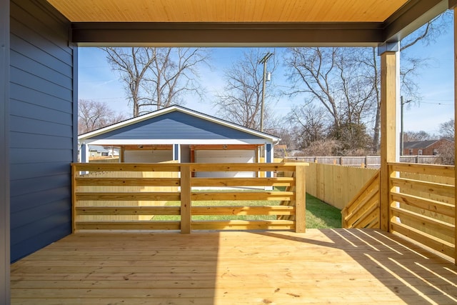 wooden terrace featuring fence and an outdoor structure