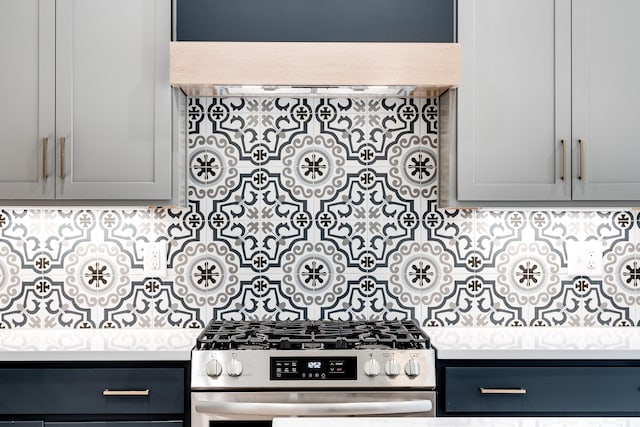 kitchen with light countertops, stainless steel gas range oven, and backsplash