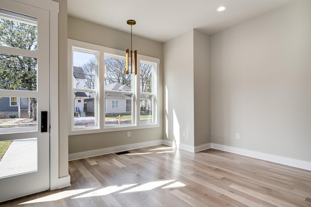 unfurnished dining area featuring recessed lighting, baseboards, and wood finished floors